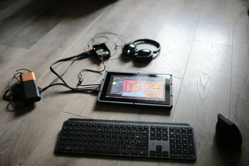A screen on a ground displaying OpenRA on Raspbian OS. The screen is plugged to a battery, a raspberry pi and an headphone.